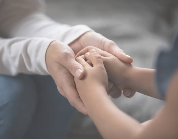 A parent holding a child’s hand symbolic of how to co parent successfully