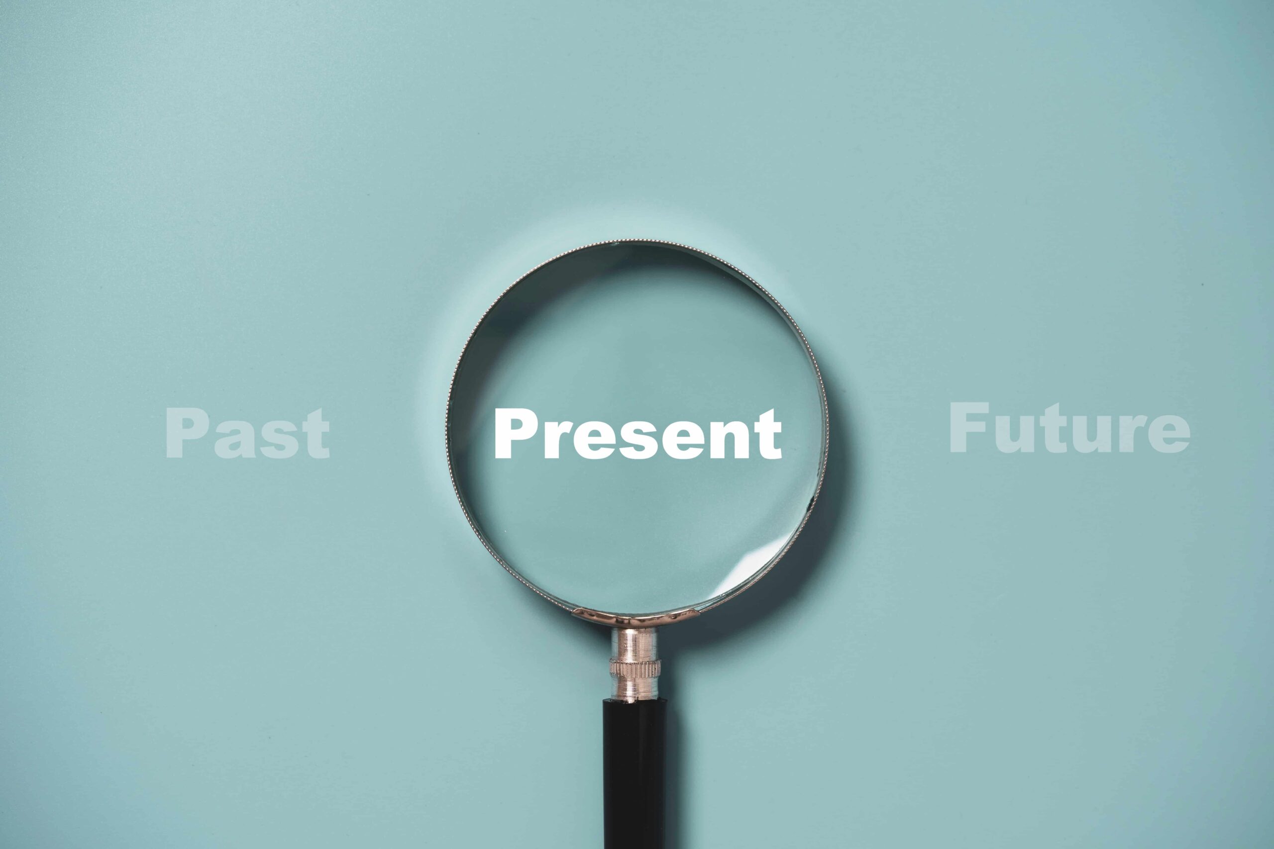 The word ‘Present’ inside of a magnifying glass on a blue background. Symbolic of what people need to do in the present or current moment in relation to how to get a divorce in Australia