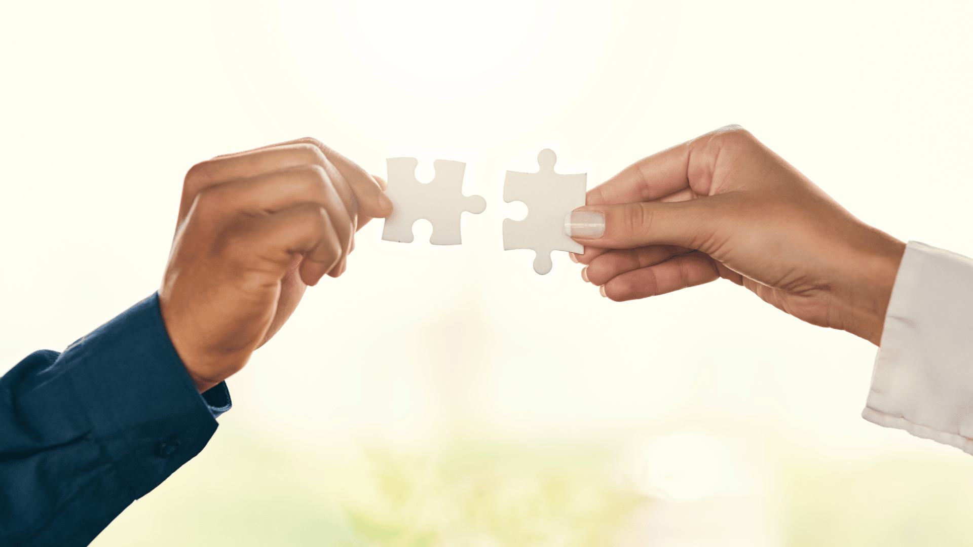 Two people with one puzzle piece each are putting the pieces together. To symbolise criminal lawyers finding ways to resolve criminal matters in the best way for clients.