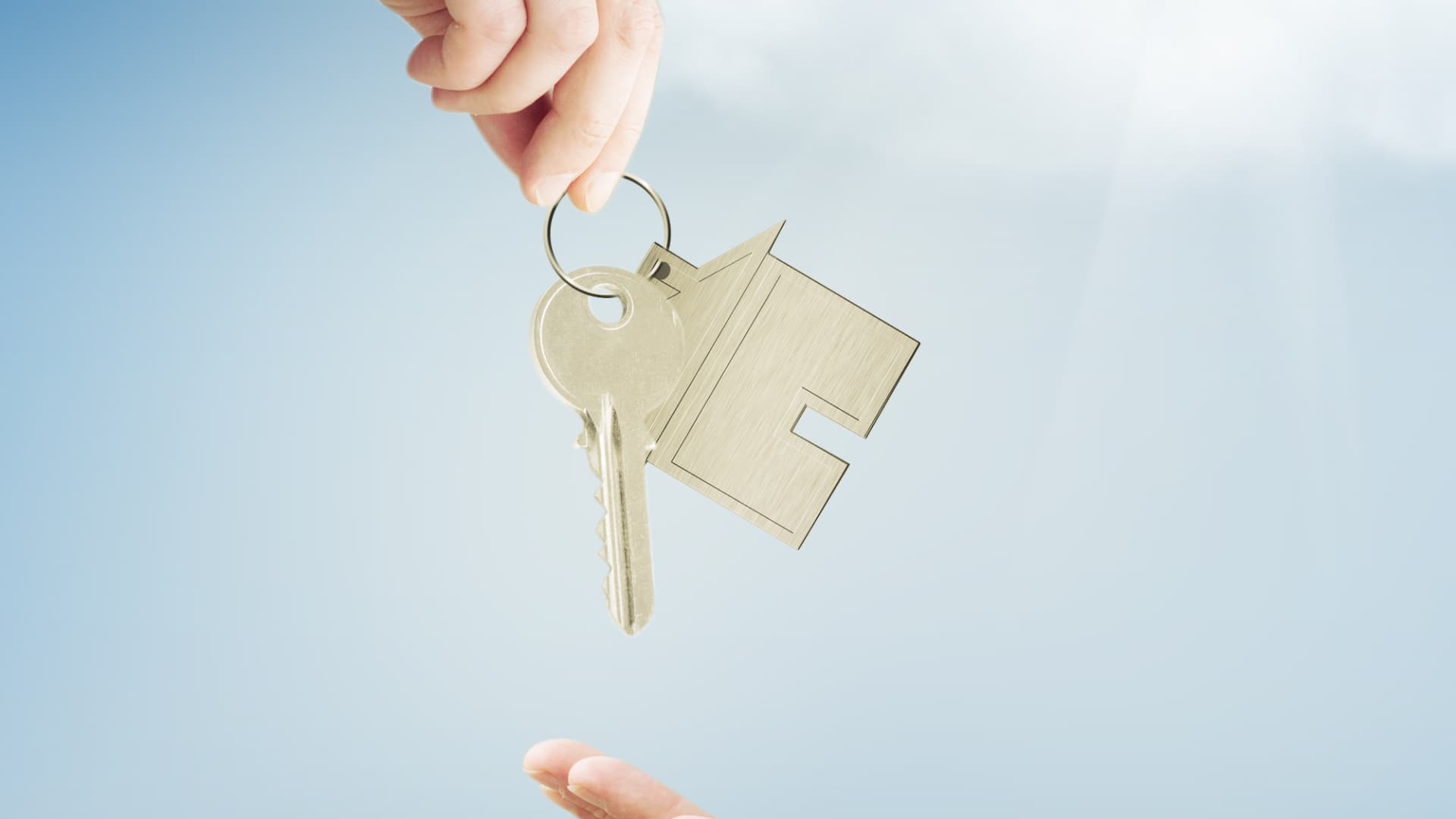Person handing house keys to another person. Conveyancing Solicitors Sydney.